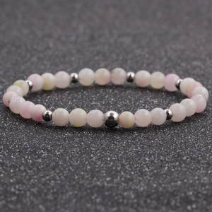 Macro shot of 6mm natural pink and white agate beads with polished silver spacers on elastic cord