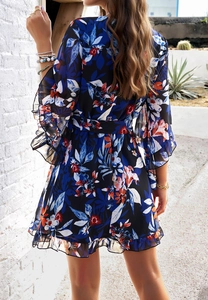 Detail of floral chiffon dress featuring ruffled cuffs and a self-tie waist belt