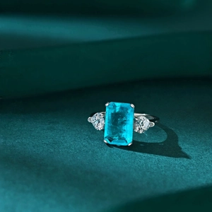 Macro shot of S925 silver ring with emerald-cut Paraiba blue stone and heart side accents