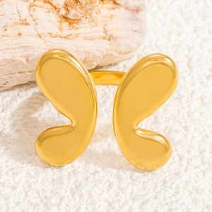 Minimalist golden butterfly stainless steel ring on natural stone texture background