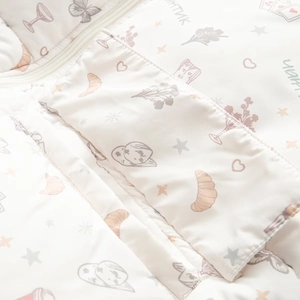 Detail der gesteppten Baumwolljacke mit Reißverschluss und weichem Blumendruck in Creme