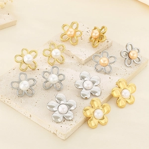Détail de boucles d'oreilles fleurs creuses en or 18K et argent avec perles au centre