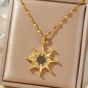 Collier avec pendentif soleil doré et zircons présenté sur une boîte en velours