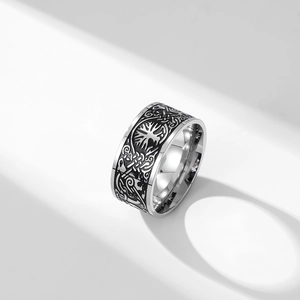Macro shot of silver Tree of Life and Celtic knot relief on a wide Viking band ring