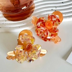 Elegant acetate 3D flower hair clips in vibrant orange marble and floral patterns
