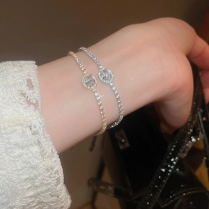 Detail of elegant gold and silver tennis bracelets with oval zircon crystals on wrist