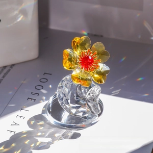 Detailed view of amber crystal flower with red core on a faceted glass base