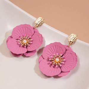 Detail of pink-purple flower earrings with matte texture petals and white pearl centers