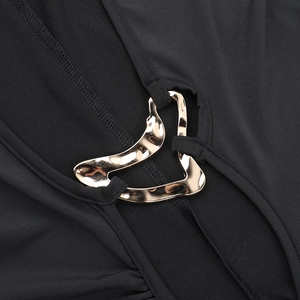 Close-up of golden heart-shaped metal buckle on black knitted backless dress