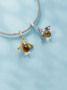 Macro detail of S925 sterling silver honey bee pendant with amber crystal and micro-pave stones