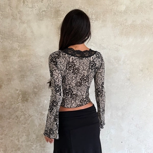 Back view of sexy lace long sleeve top with intricate floral patterns and flared cuffs