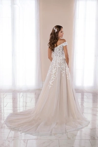 Detail of the champagne and white lace off-the-shoulder evening gown with long tulle train