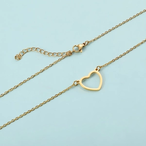 Elegant gold hollow heart pendant necklace in stainless steel on a light blue background