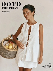 Detail of white sleeveless top featuring four elegant bow ties and breathable texture