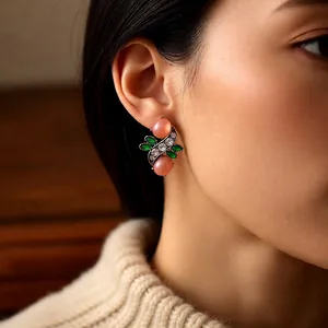 Vintage gold-tone oval earrings with pink and green rhinestones worn by a model
