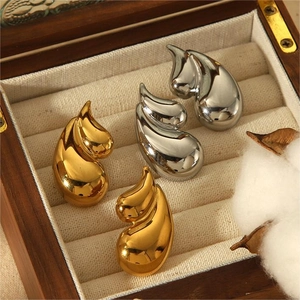 Polished 18k gold and silver teardrop earrings in a vintage wooden jewelry box