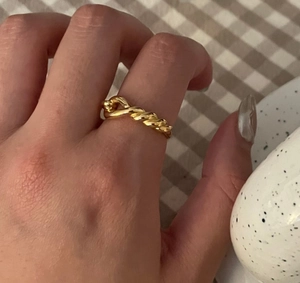 Detailed close-up of a vintage twisted knot pattern on a golden metallic ring