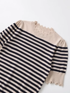 Detail of scalloped neckline and pointelle hollow knit on striped long sleeve top