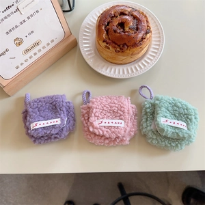 Close-up of plush lamb wool mini pouches in purple, pink, and mint green with lanyards