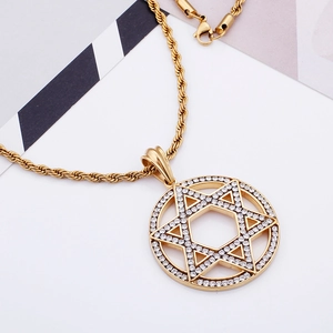 Detailed close-up of golden hexagram pendant with sparkling crystals on rope chain