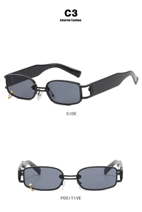 Detail of black square sunglasses with a hanging gold ring and hollow metal hinges