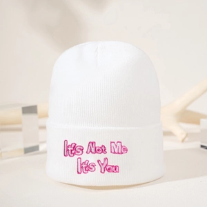 Gros plan d'un bonnet blanc en tricot avec broderie rose It's Not Me It's You