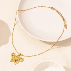 Close-up of gold stainless steel necklace clasp with lobster claw and butterfly pendant