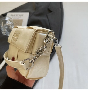 Détail du mini sac carré tressé crème avec chaîne argentée et texture PU souple