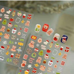 Detailed view of Christmas nail art stickers featuring bears, trees, and festive patterns