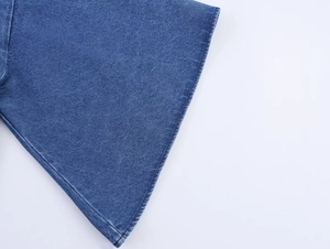 Nahaufnahme eines Jeanshemds mit hochdichtem Köperstoff und feinen Nahtdetails am Saum