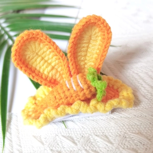 Close-up of handmade crochet carrot hair clip with orange bunny ears for girls
