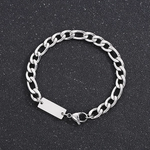 Detail of silver Figaro chain necklace with a rectangular blank pendant on dark background