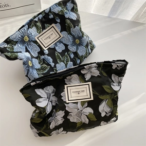 Close-up of floral jacquard canvas storage bags with Pleasant Time labels and zipper details