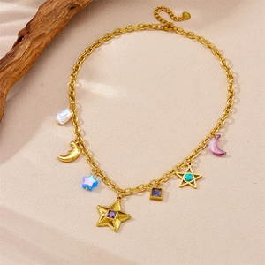 Detail of vintage gold plated necklace featuring celestial star, moon and pearl pendants