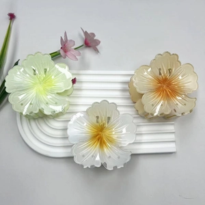 Tre eleganti fermagli per capelli a fiore in verde, bianco e ambra su supporto
