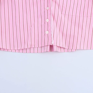 Close-up of pink striped cotton shirt with delicate white lace trim and white buttons
