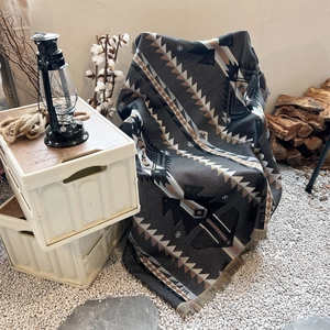 Outdoor camping blanket with dark geometric patterns and tassel edges for picnic decor