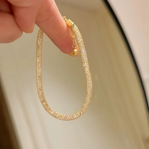 Detailed view of a gold-plated mesh bracelet with pavé zircons and adjustable chain