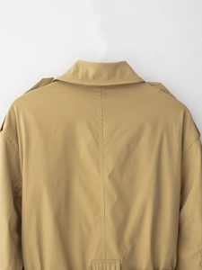 Détail du trench-coat kaki montrant le revers, les épaulettes et les coutures