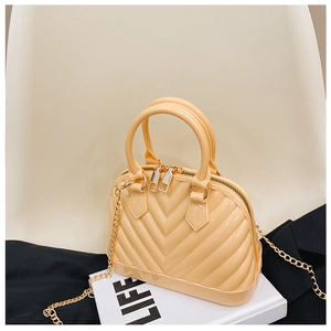 Detail of pink shell jelly bag with V-shaped embossed texture and golden chain strap