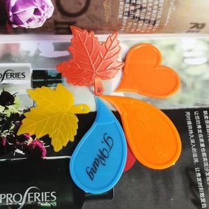 Flat lay of colorful plastic measuring spoons in heart and leaf shapes with logos