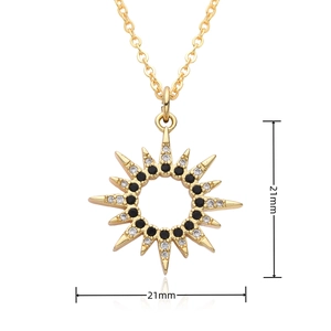 Macro shot of 21mm gold sunburst pendant with black and clear zircon stones