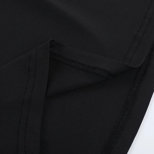 Detailed close-up of double-needle stitching on the hem of a black bodycon mini dress