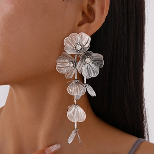 Detailed view of silver mesh petal earrings with sparkling rhinestone centers and tassels