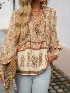 Detail of bohemian floral V-neck blouse with lace-up tassels and long sleeves