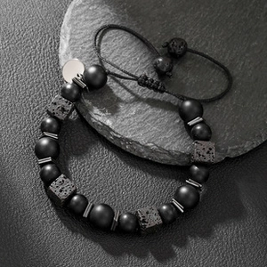Macro detail of men's beaded bracelet featuring lava stone and matte black beads