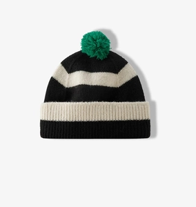Close-up of knitted striped beanie with detailed texture and a green pom-pom on top