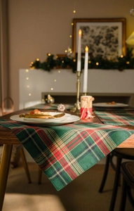 Macro shot of red and green plaid table runner texture with festive golden cutlery