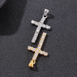 Détail de pendentifs croix en argent et or 18K avec strass sur fond noir texturé