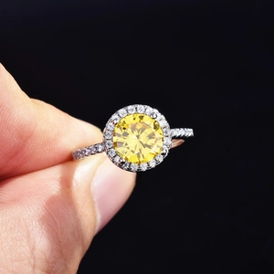 Elegant halo ring with round yellow gemstone and white pavé diamonds in silver finish